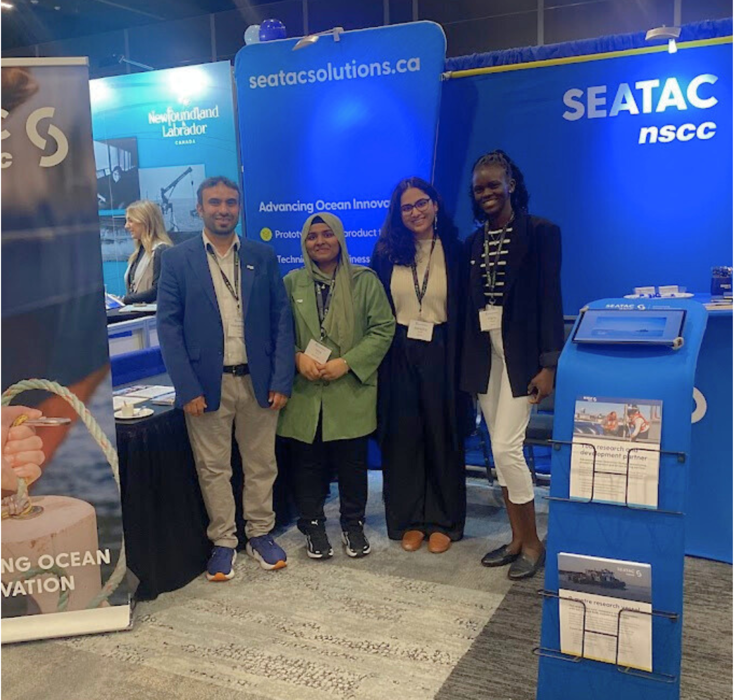 Aprajita poses for a photo with three other COVE interns in the SEATAC booth at the H2O conference.